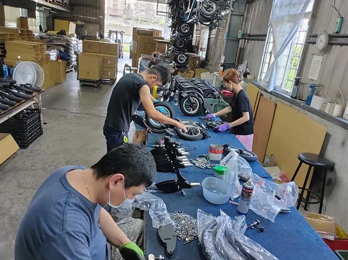 Workers assembling mobility components at a practical workbench